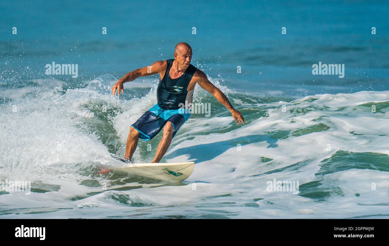 Playa Hermosa, Guanacaste, Costa Rica - 07.26.2020: Un uomo anziano molto adatto (oltre 50 anni) che mostra eccezionali abilità di surf a Pacific Coast Foto Stock