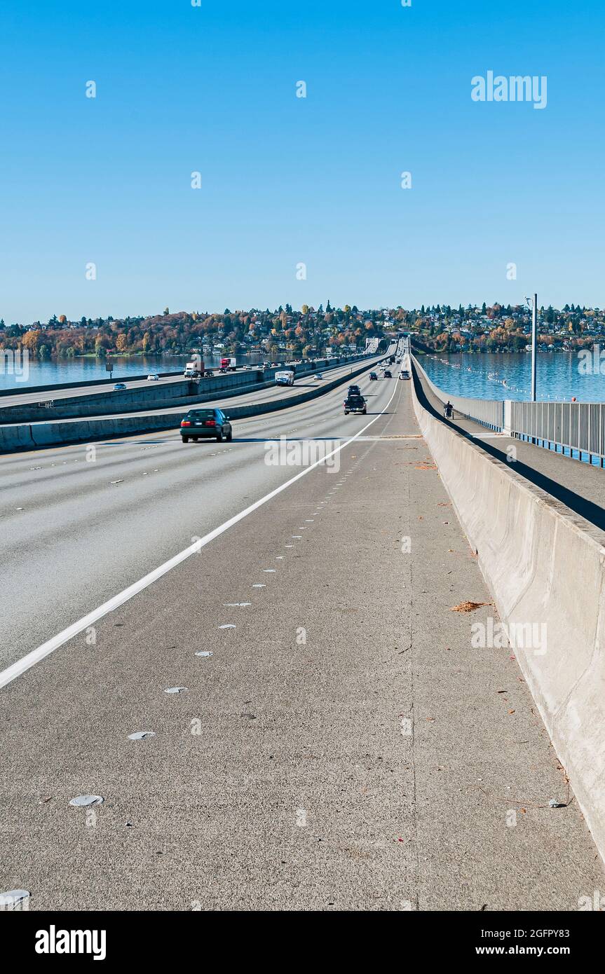 Uomo pedalando in sentiero pedonale a destra di foto sul ponte che attraversa il Lago Washington, zona Eastgate, vicino a Bellevue, Washington. Foto Stock