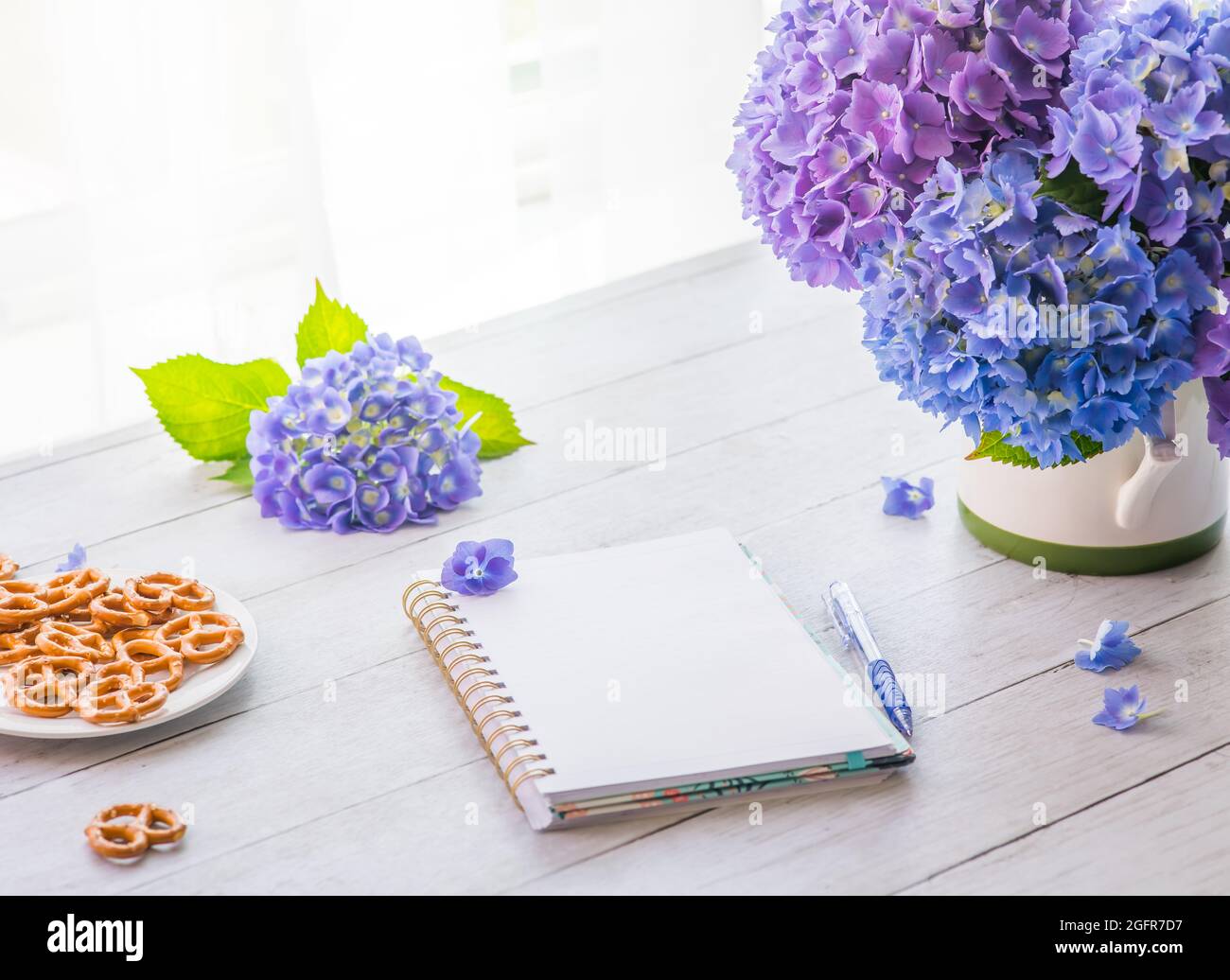 Fiori di hydrangea con il taccuino sul tavolo con spazio di copia per il testo Foto Stock