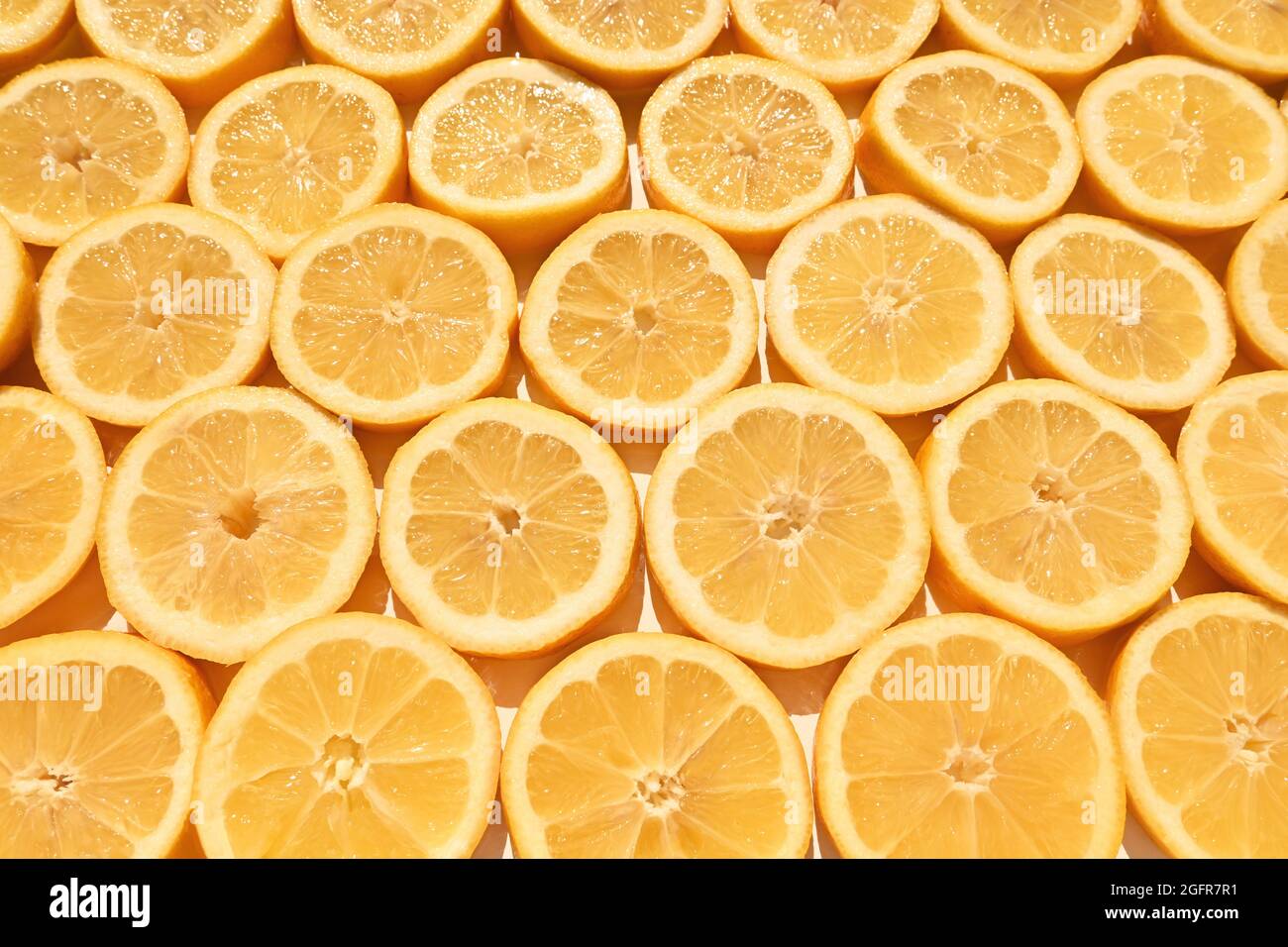 Limoni tagliati gialli posti sul tavolo. Fette tagliate: Texture succosa fresca. Foto Stock
