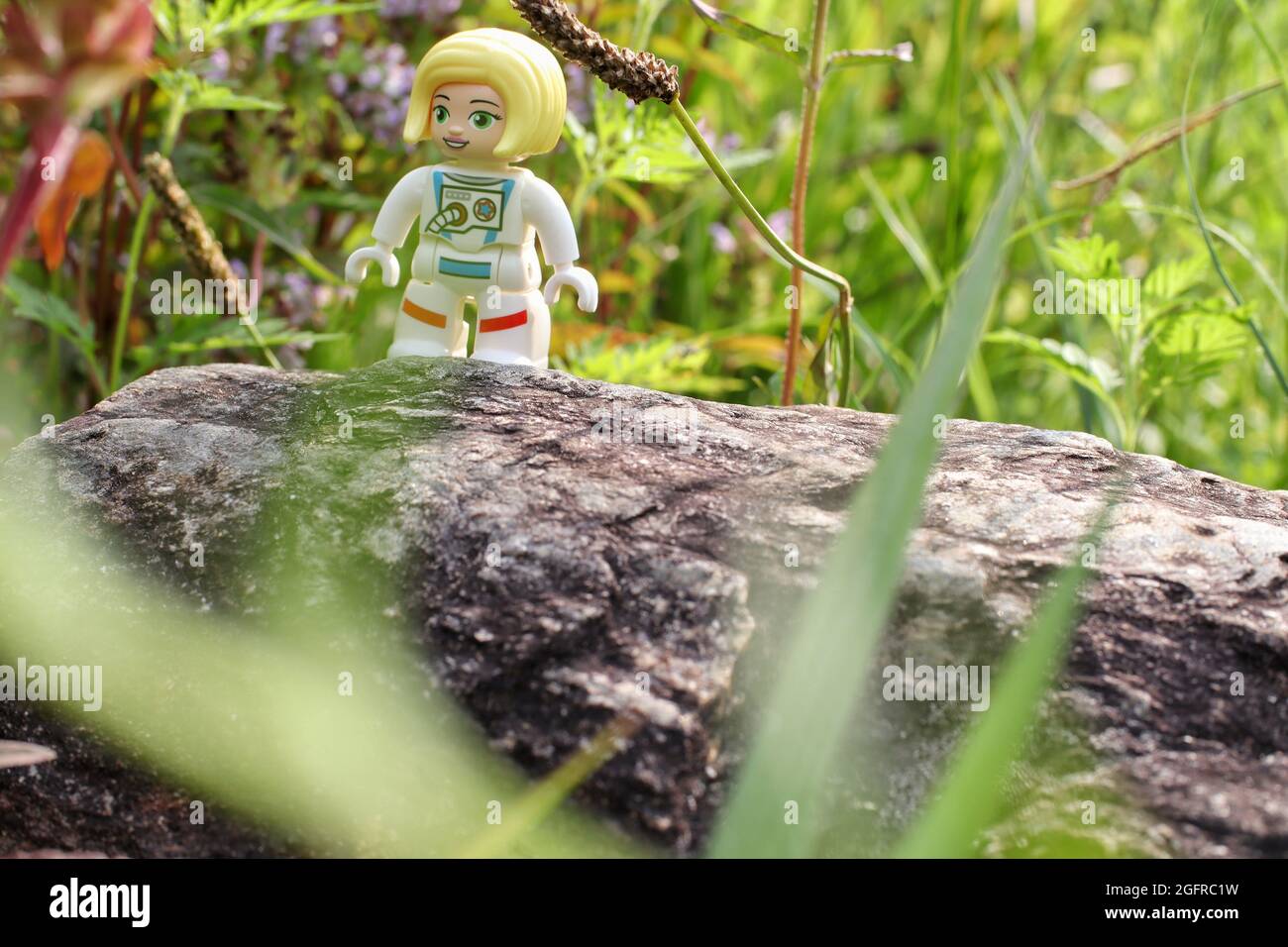 GREENVILLE, STATI UNITI - 31 luglio 2021: Un primo piano di una figura di astronauta giocattolo Lego sul legno su sfondo verde Foto Stock