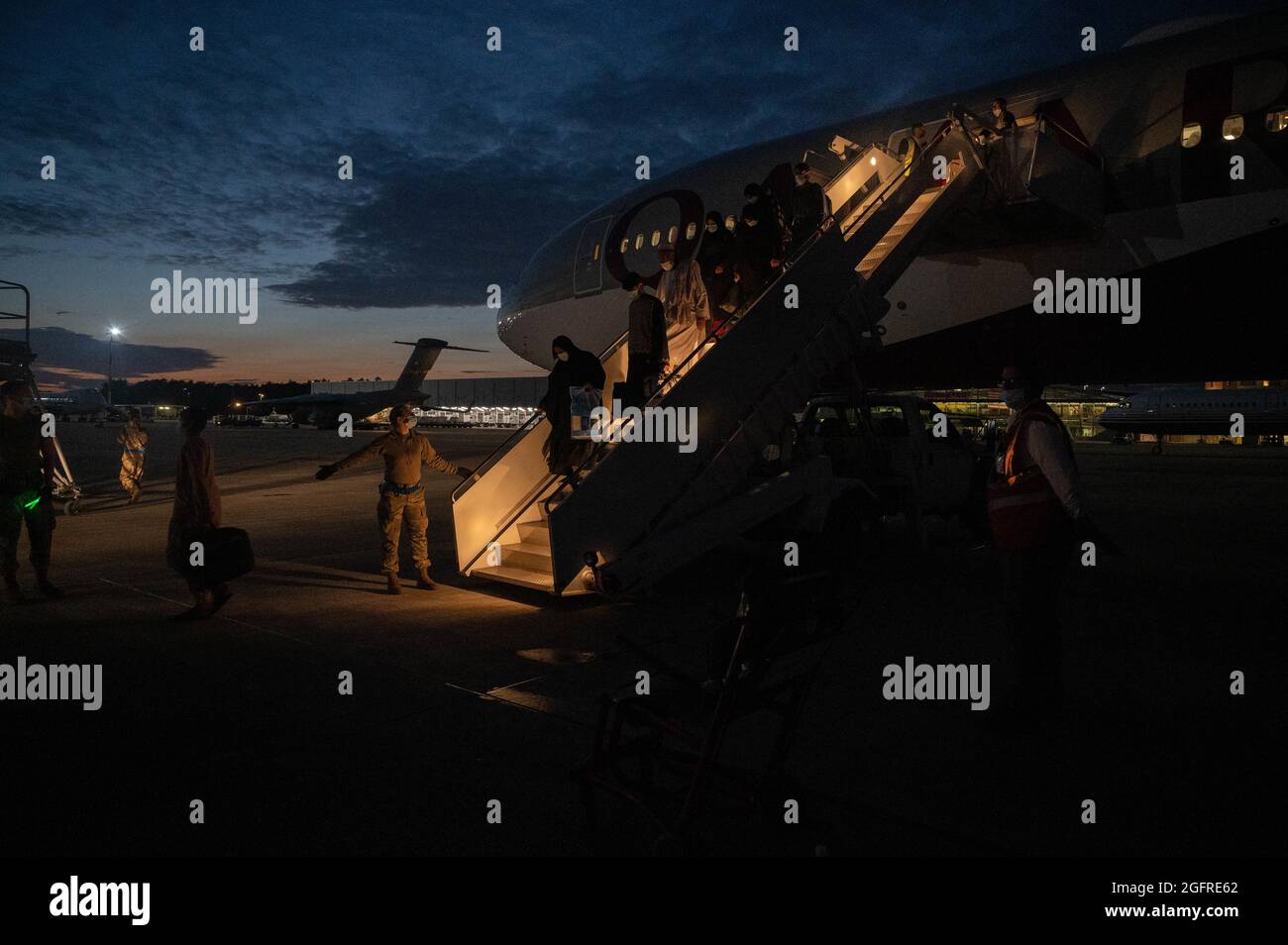 Gli evacuati partono da un aeromobile Boeing 777-300 della Qatar Airways alla base aerea di Ramstein, Germania, 25 agosto 2021. Qatar Airways sta aiutando a trasferire gli sfollati afghani durante l'operazione Allies Refuge. (STATI UNITI Air Force foto di Senior Airman Taylor Slater) Foto Stock