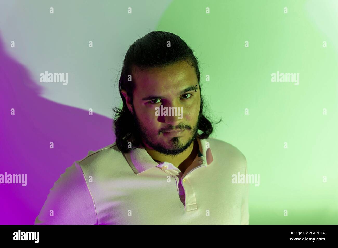 uomo gay con luci colorate che guardano la macchina fotografica Foto Stock