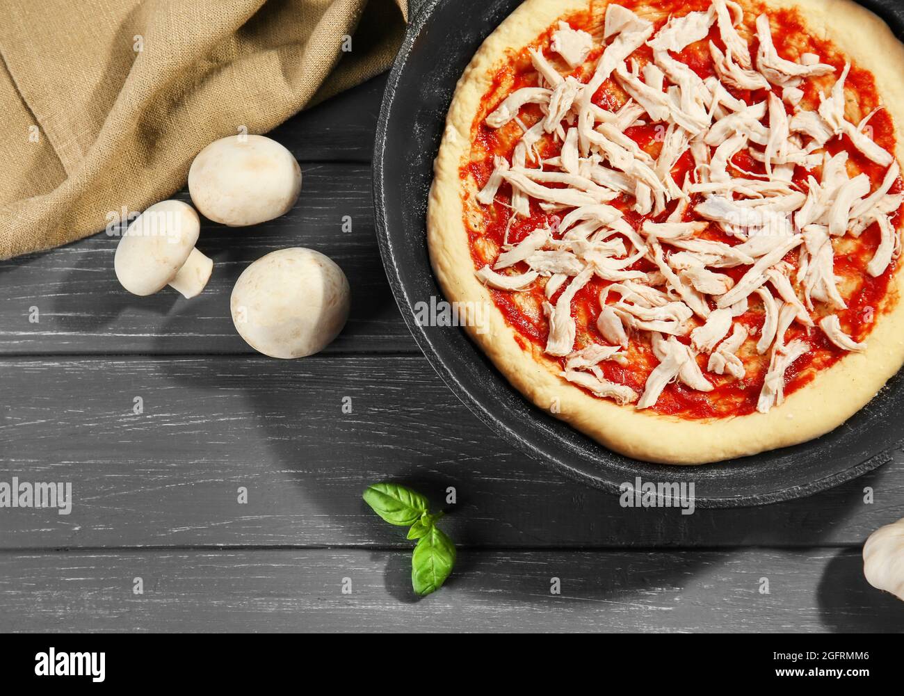 Pizza non cotta in padella su tavolo di legno Foto stock - Alamy
