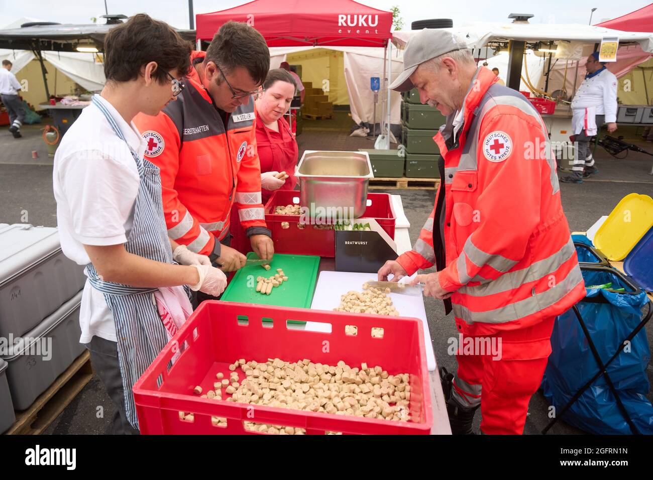 Grafschaft, Germania. 23 Agosto 2021. L'equipaggio della cucina del centro di ristorazione tedesco della Croce Rossa sta già cucinando il pranzo al mattino. Qui, più di 10000 pasti sono preparati tre volte al giorno per le vittime del disastro alluvionale dell'Ahr e per i numerosi aiutanti. Credit: Thomas Frey/dpa/Alamy Live News Foto Stock