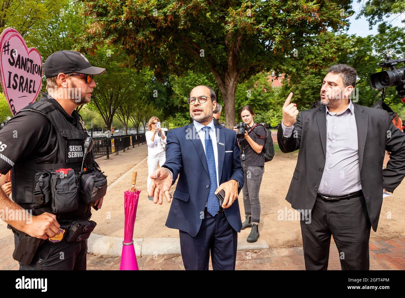 Washington, DC, USA, 26 Agosto, 2021. Nella foto: Nihad Awad (centro), direttore esecutivo del Consiglio per le relazioni americano-islamiche, e Dr. Osama Abuirshaid (destra), Il direttore esecutivo dei musulmani americani per la Palestina si oppone alla riduzione dei loro primi diritti di emendamento quando un funzionario del Servizio Segreto li informa che devono lasciare Lafayette Park durante una protesta contro la prima visita di Naftali Bennett alla Casa Bianca come primo ministro di Israele. L'ordine di partenza è molto insolito, in quanto il Servizio Segreto permette proteste nel parco ogni giorno. Credit: Allison Bailey / Alamy Live News Foto Stock