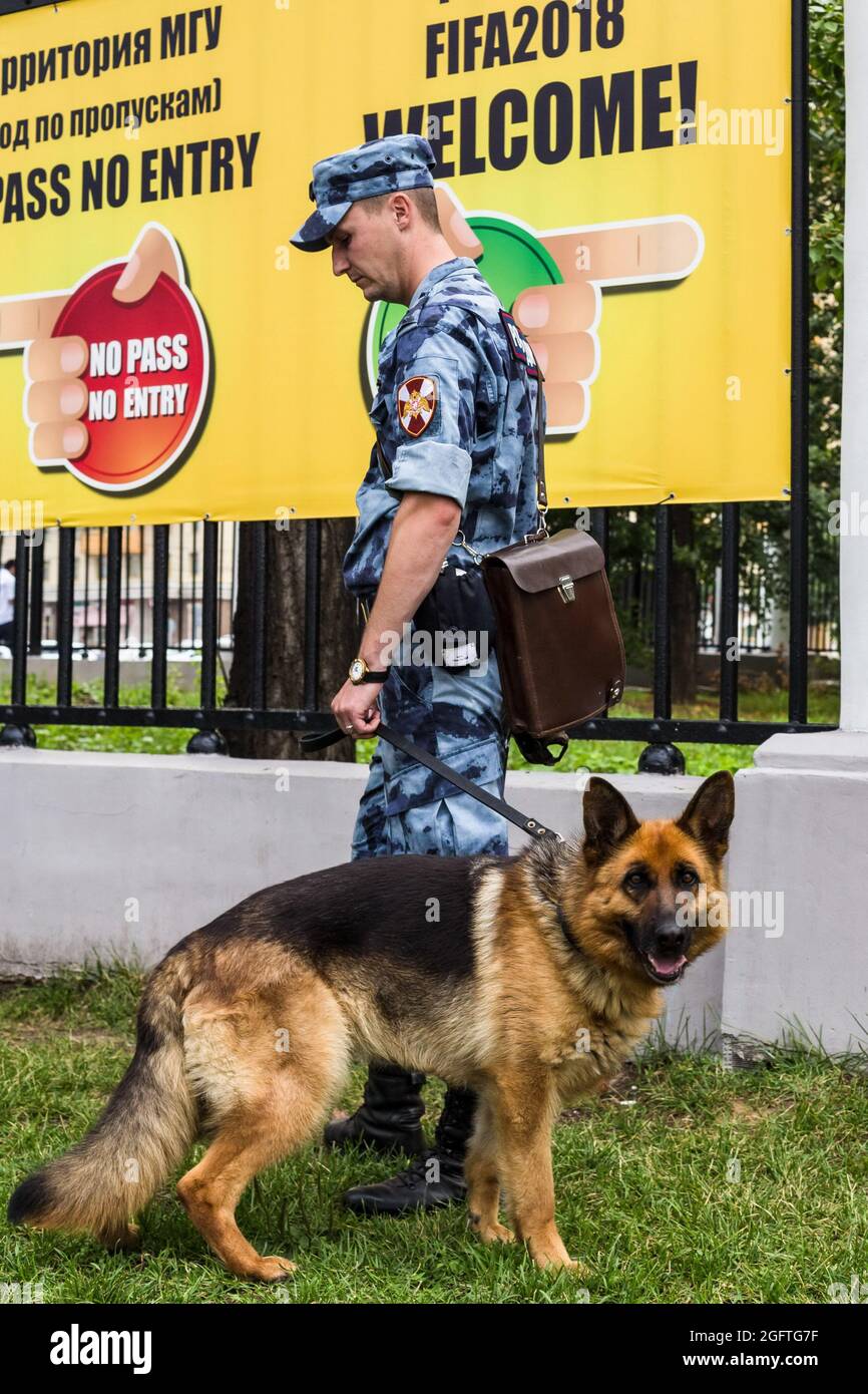 Mosca, Russia. 15 luglio 2018. Un dipendente della Guardia Nazionale con un cane di servizio controlla la sicurezza della zona fan.per la comodità dei tifosi di calcio nelle città russe, sono stati organizzati luoghi per la visione congiunta di massa di trasmissioni dal vivo di partite di calcio della Coppa del mondo su schermi enormi. La protezione antiterrorismo e il mantenimento dell'ordine pubblico in questi luoghi sono stati forniti da ufficiali della Guardia Russa. (Credit Image: © Mihail Siergiejevicz/SOPA Images via ZUMA Press Wire) Foto Stock