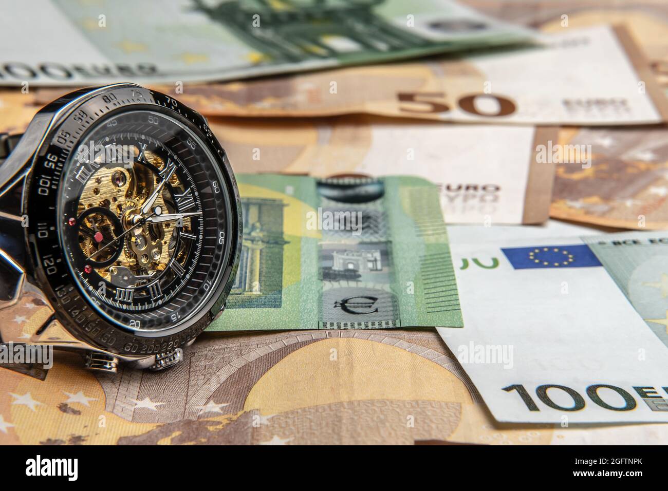 Il tempo è money.A bello orologio meccanico in primo piano si trova  sull'euro money.Manual contare delle banconote in euro.Cash euro bls.The  storia di contanti dentro Foto stock - Alamy