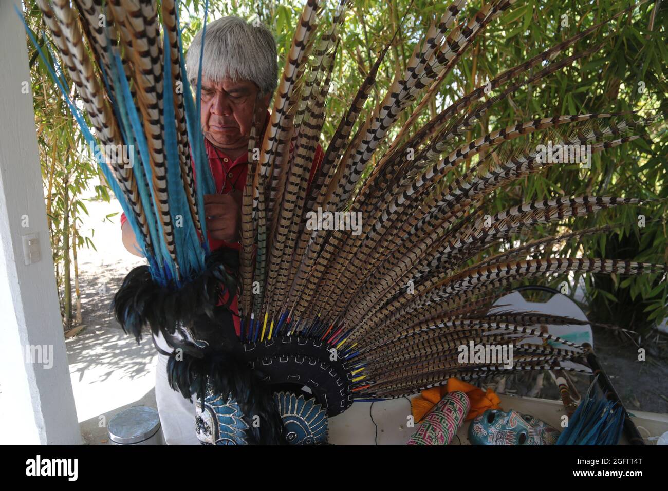 Un uomo mette le piume in un pennacchio prima vestito come guerriero azteco come parte di una cerimonia pre-ispanica nella zona archeologica. Teotihuacan, Messico, 26 agosto 2021. Foto di Ricardo Castelan/Eyepix/ABACAPRESS.COM Foto Stock