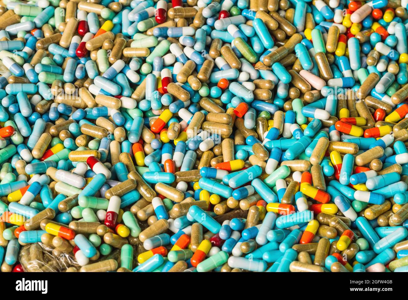Molte medicine colorate scadono sul pavimento di cemento Foto Stock