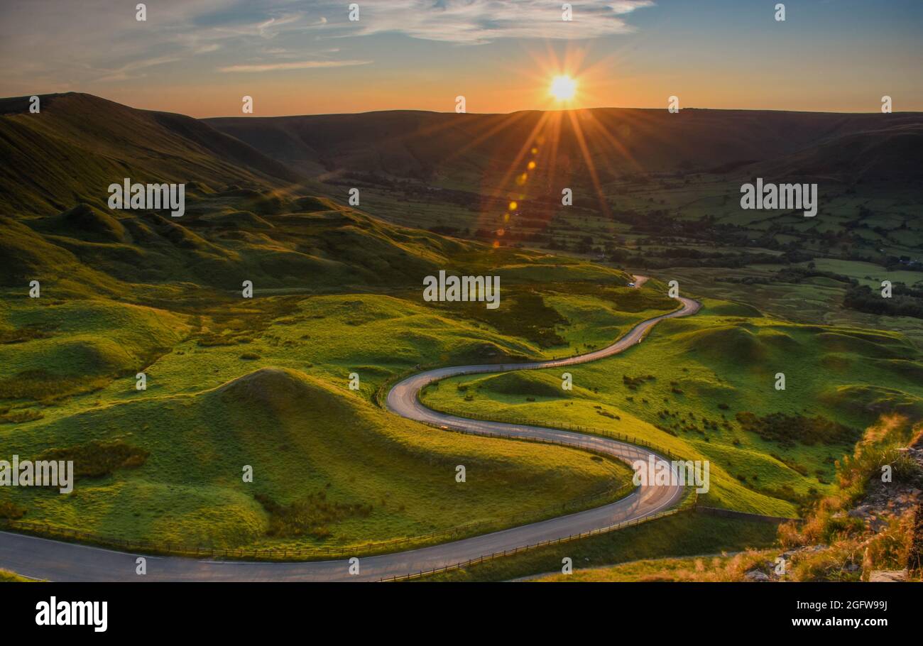 MAM Tor Tramonto. Il sole si trova su una strada tortuosa nella Valle di Edale Foto Stock