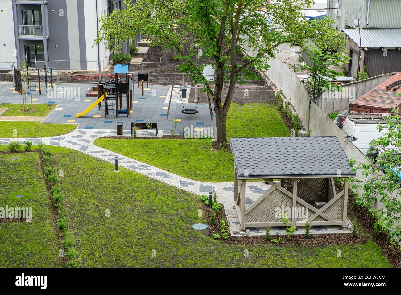 Il cortile di un nuovo e moderno edificio residenziale. Gazebo in legno. Parco giochi per bambini. Erba verde. Nessuno. Vista dall'alto. Foto Stock