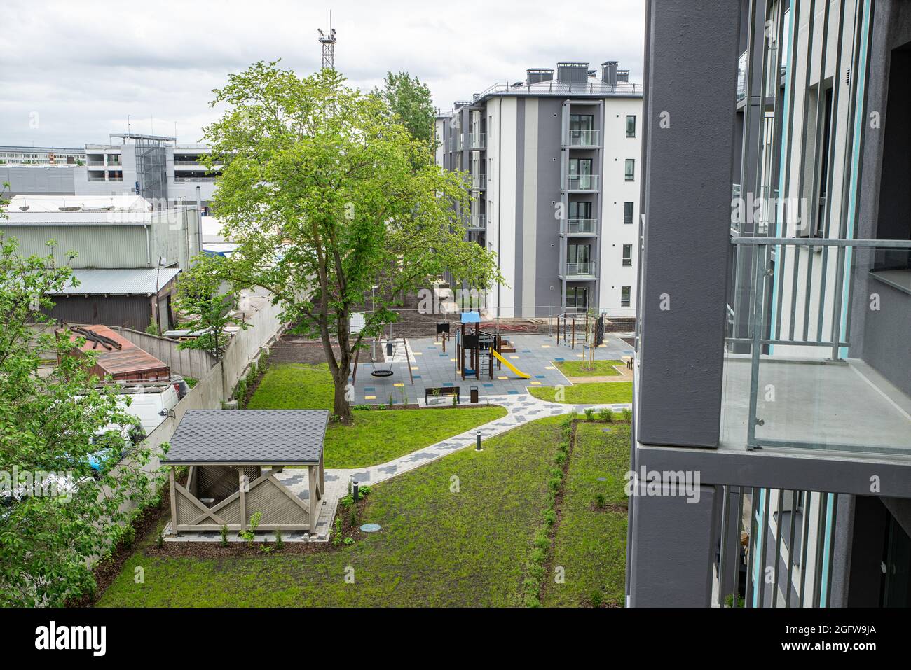Il cortile di un nuovo e moderno edificio residenziale. Gazebo in legno. Parco giochi per bambini. Erba verde. Nessuno. Vista dall'alto. Foto Stock