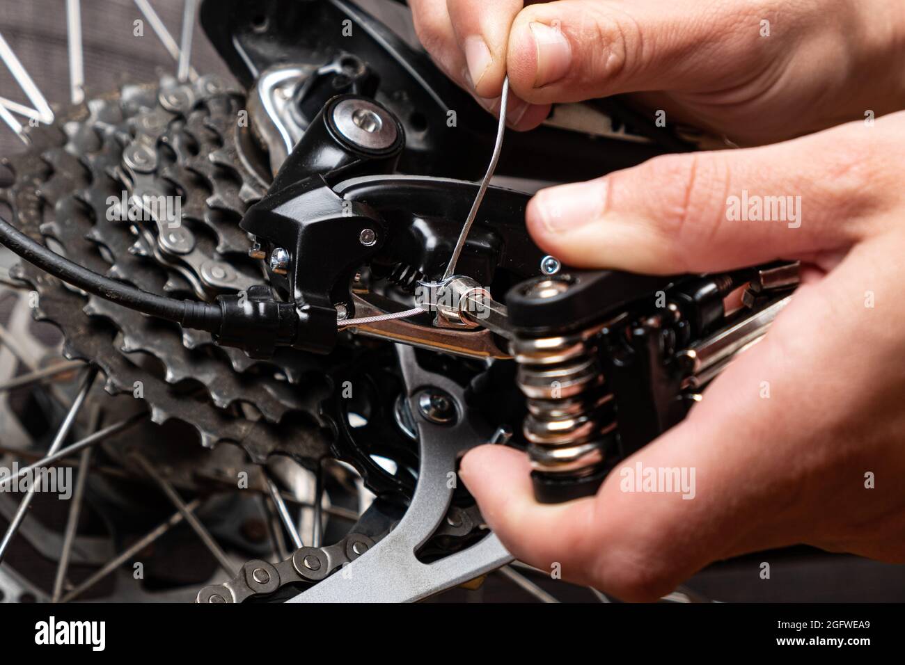 serraggio del cavo di cambio marcia su una bicicletta con multitool. Foto Stock