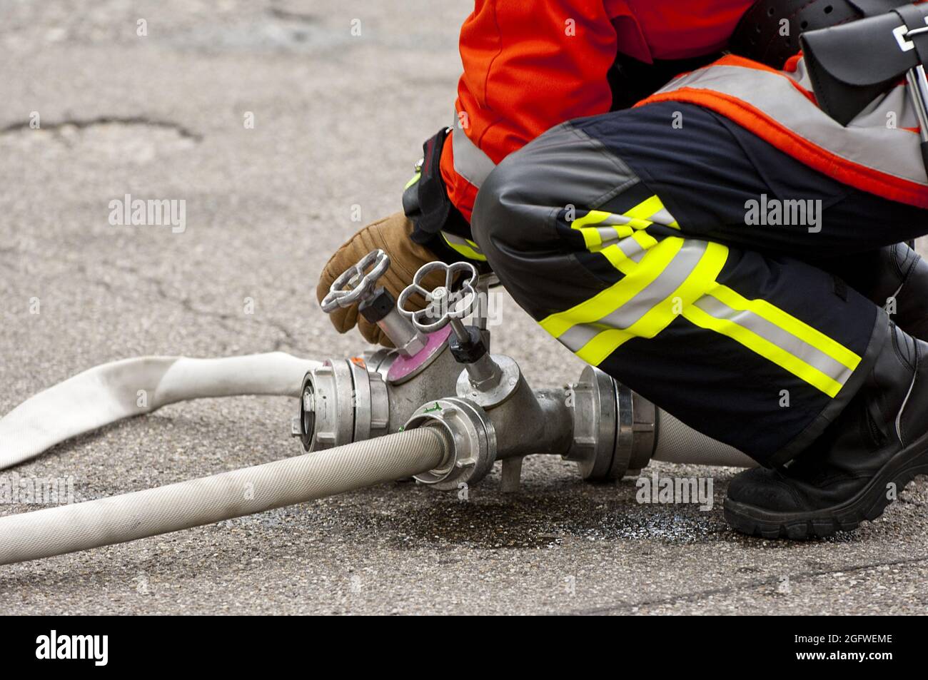 Pompiere che collega un tubo, Germania Foto Stock