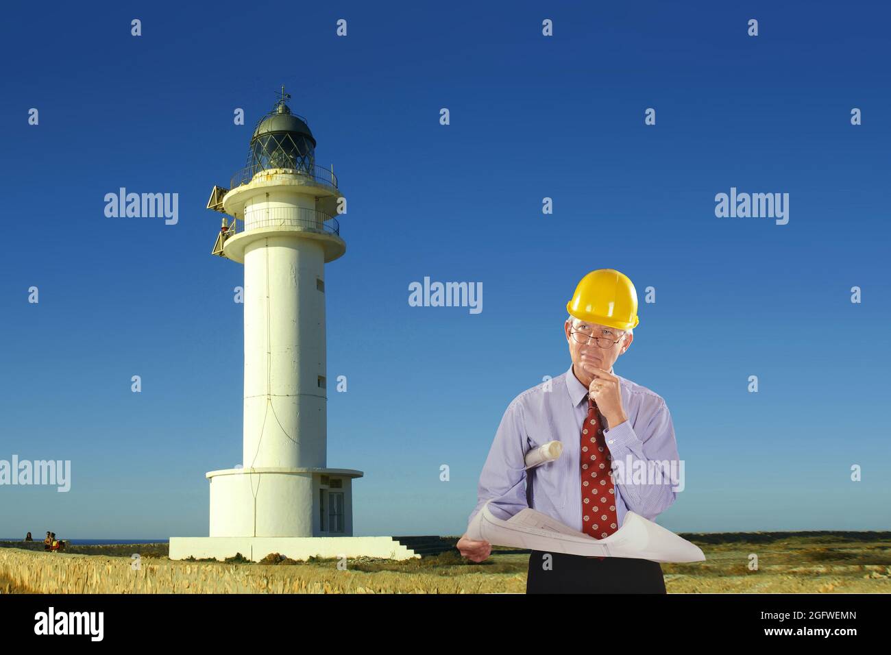 Architetto con progetto di costruzione e elmetto, faro a Cap de Barbaria sullo sfondo , Spagna, Isole Baleari, Formentera Foto Stock