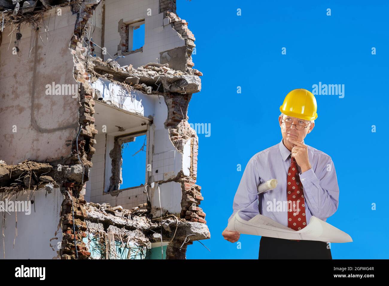 architetto con progetto di costruzione e elmetto, demolizione edificio in background Foto Stock