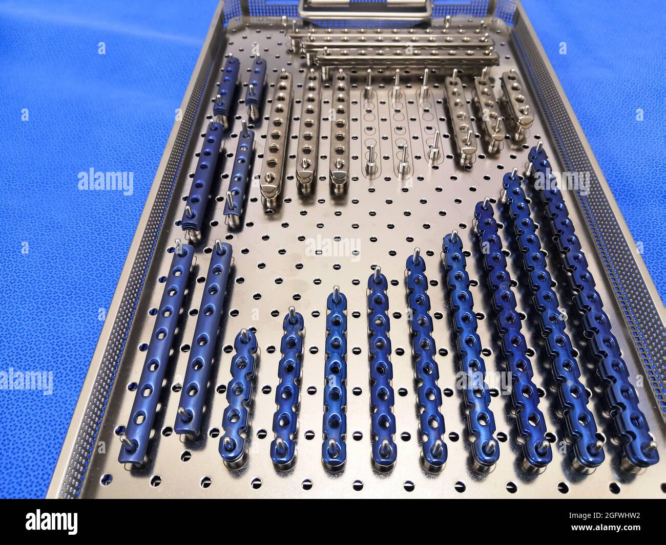Immagine closeup delle piastre in acciaio inox per impianti ortopedici poste nel suo contenitore. Messa a fuoco selettiva Foto Stock