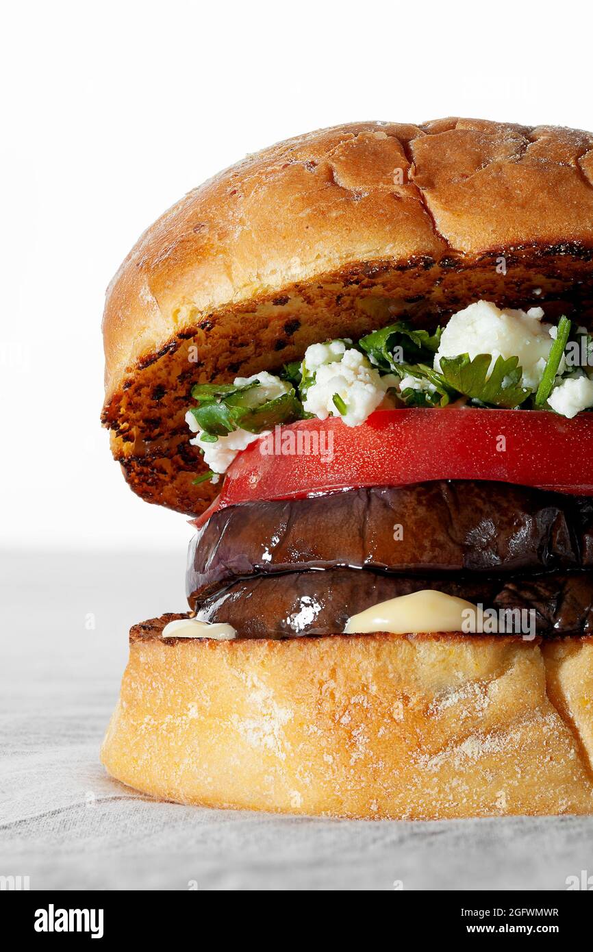 Hamburger vegano con melanzane grigliate su sfondo bianco. Cibo sano a base di piante Foto Stock
