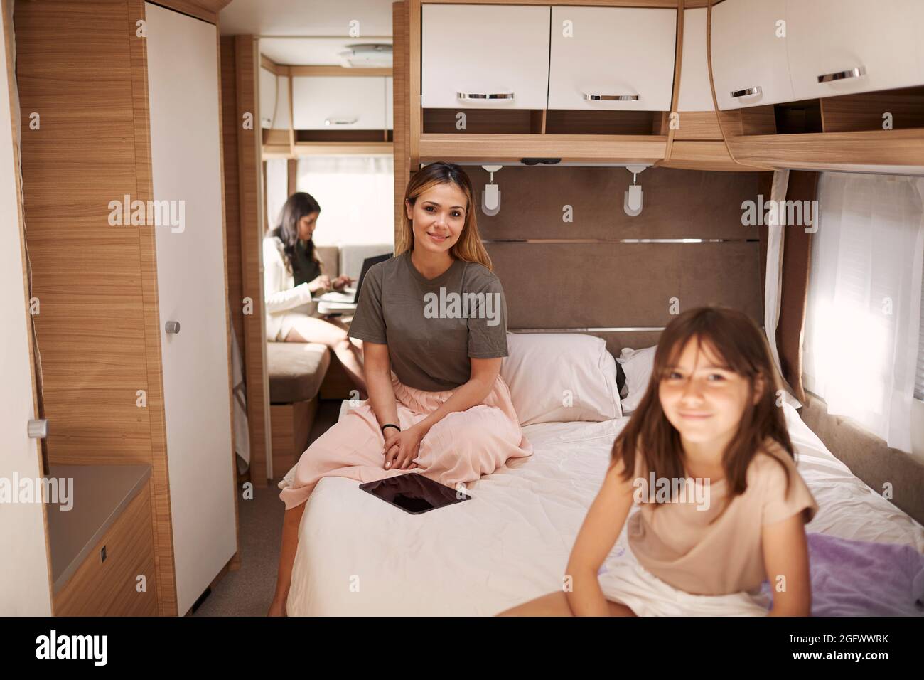Madre e figlia sedute a letto in camper Foto Stock