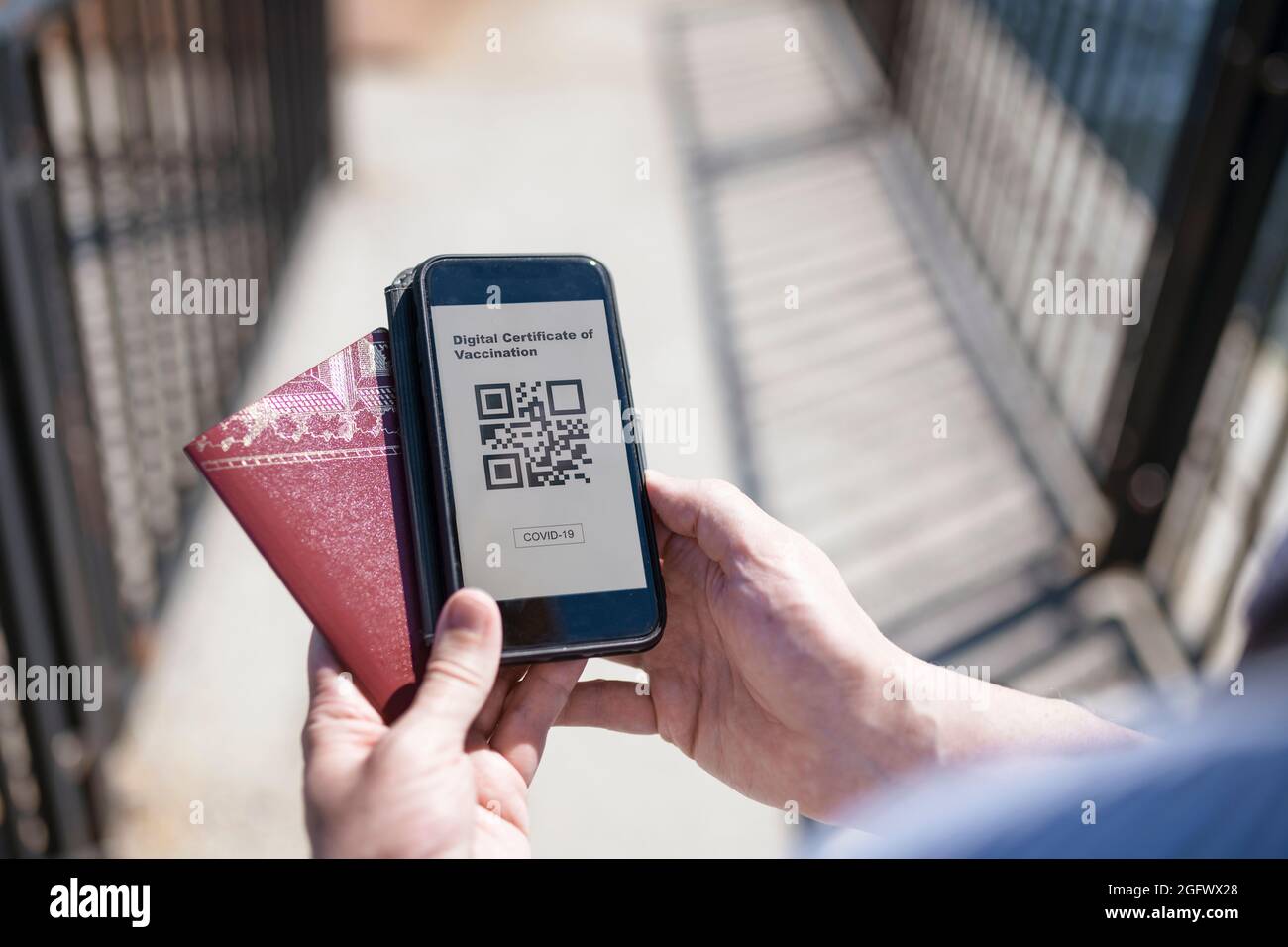 Smartphone con certificato di vaccino e passaporto Covid-19 Foto Stock