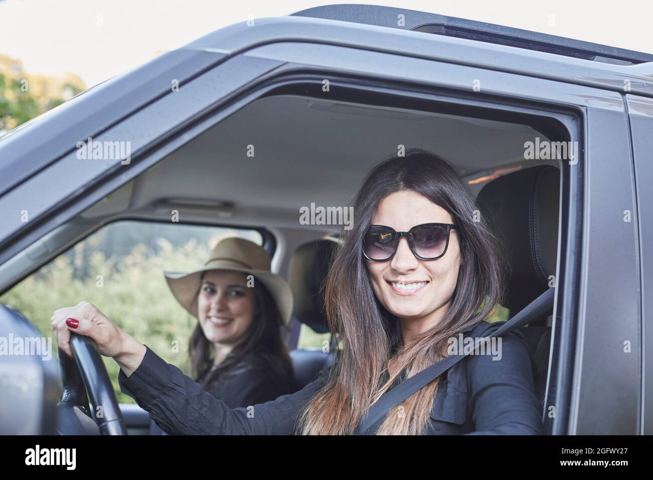 Donna sorridente seduto in auto Foto Stock