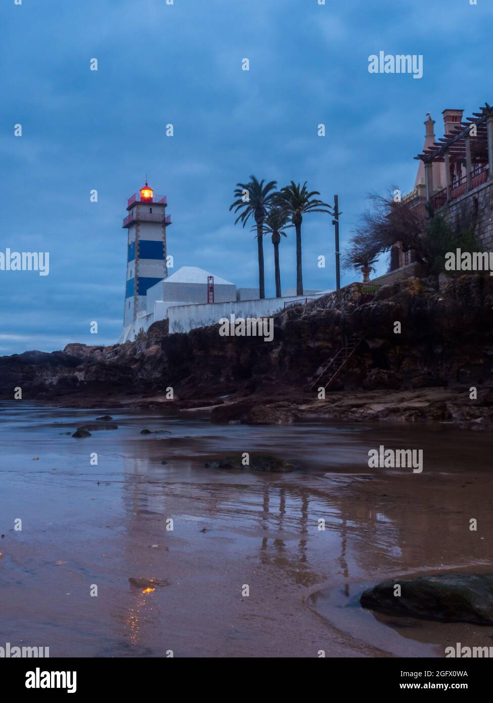 Vista all'alba del faro di Santa Marta durante il deflusso dell'oceano, in Portogallo. Foto Stock