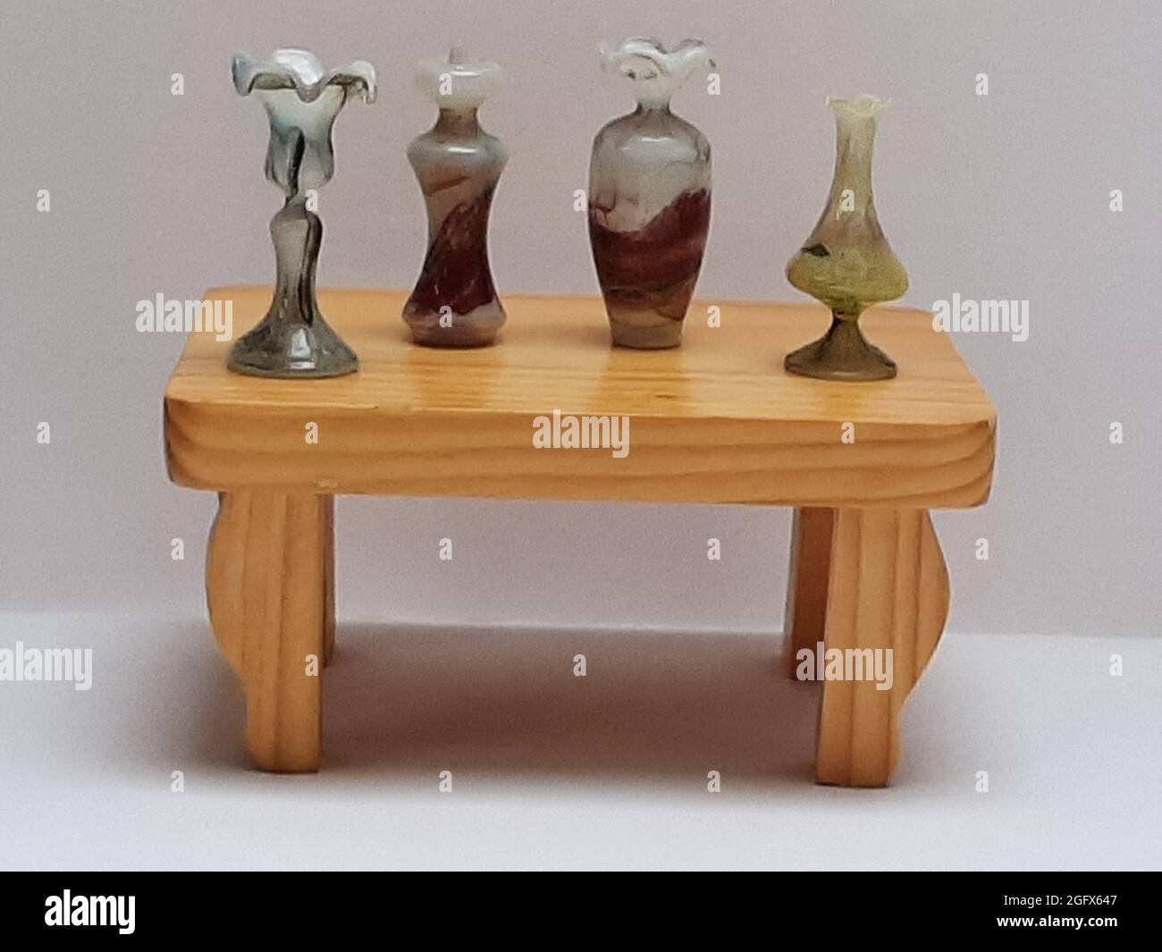 Deko Figur 4 Vasen aus Glas auf kleiner Holzbank Foto Stock