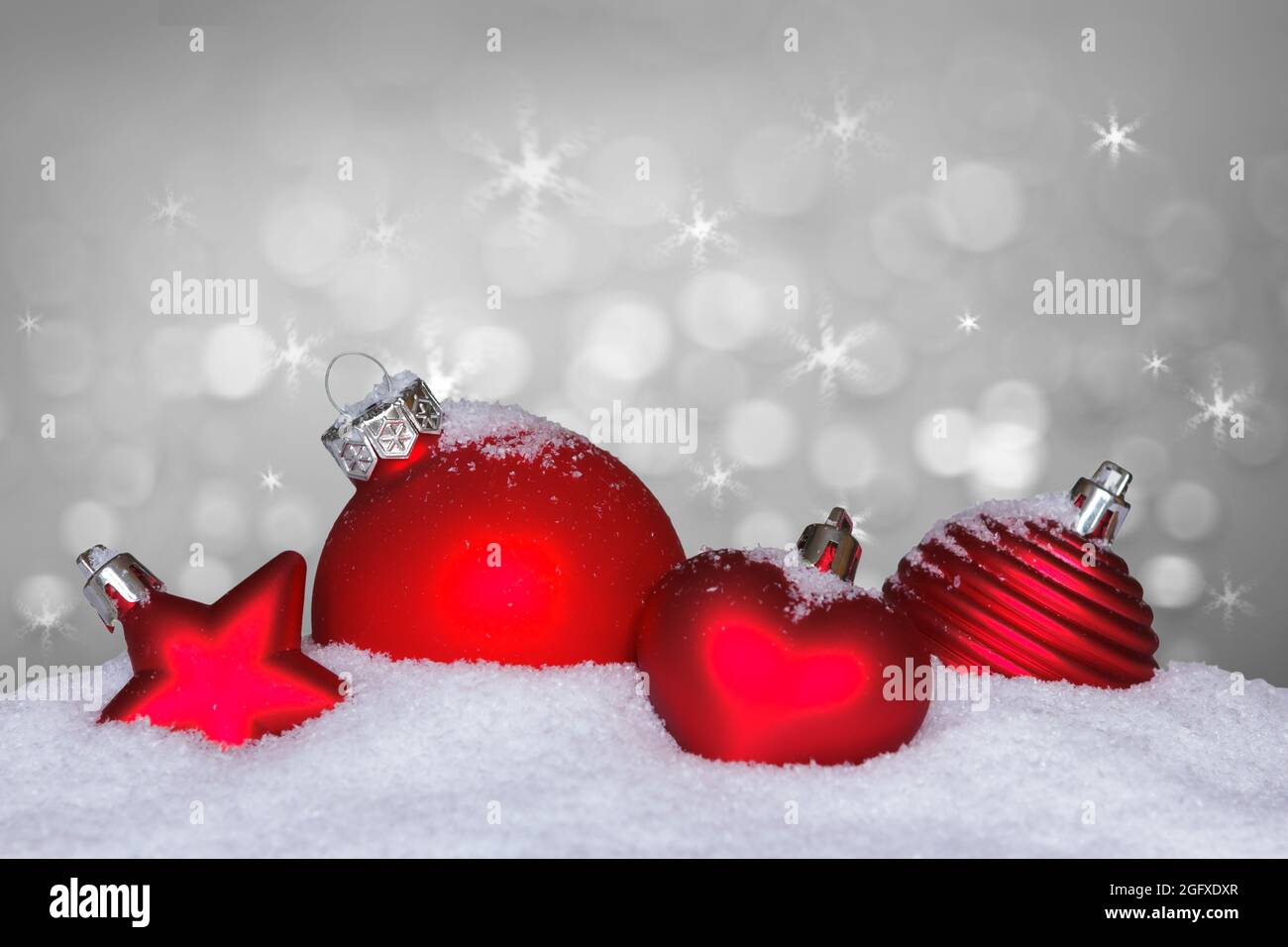 Palla di natale rossa, stella e cuore sulla neve, sfondo bianco brillante,  spazio di testo o di copia Foto stock - Alamy