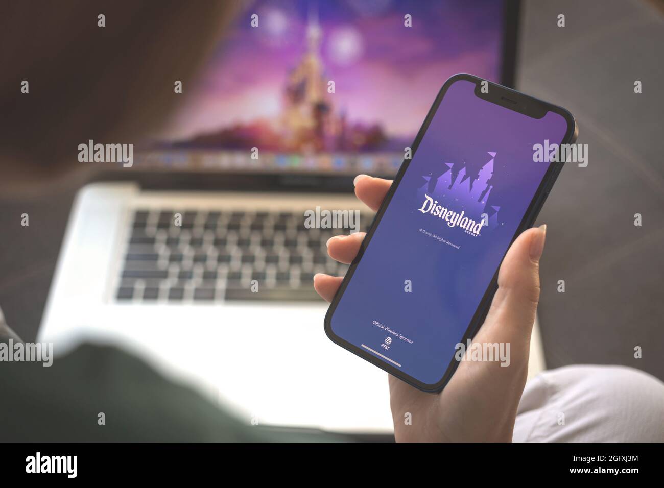 Kharkov, Ucraina - 23 agosto 2021: Donna che usa l'applicazione Disneyland. Logo dell'app Disneyland sullo schermo del telefono cellulare Foto Stock
