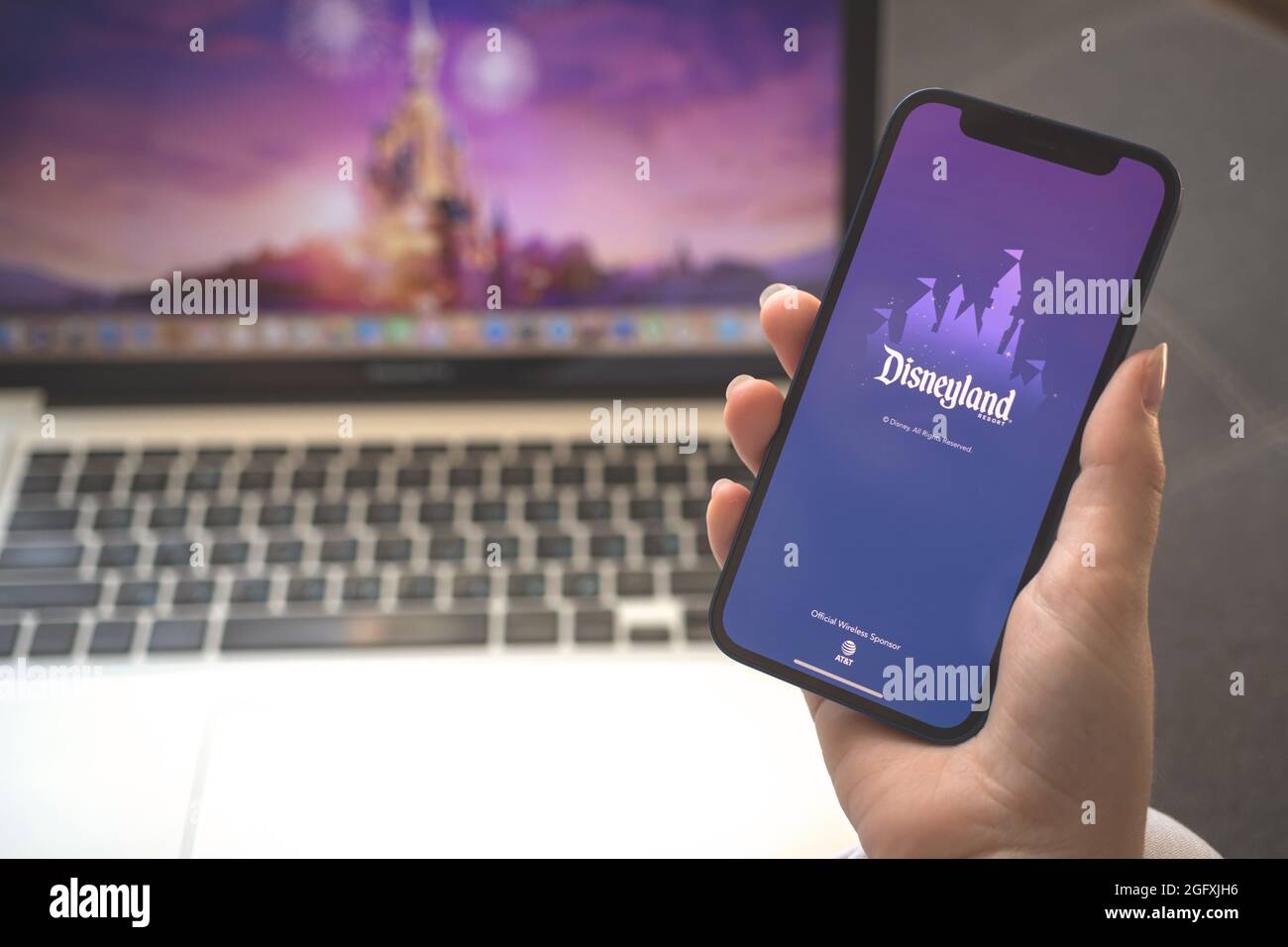 Kharkov, Ucraina - 23 agosto 2021: Logo dell'app Disneyland, schermo del telefono cellulare. Donna che utilizza l'applicazione Disneyland Foto Stock