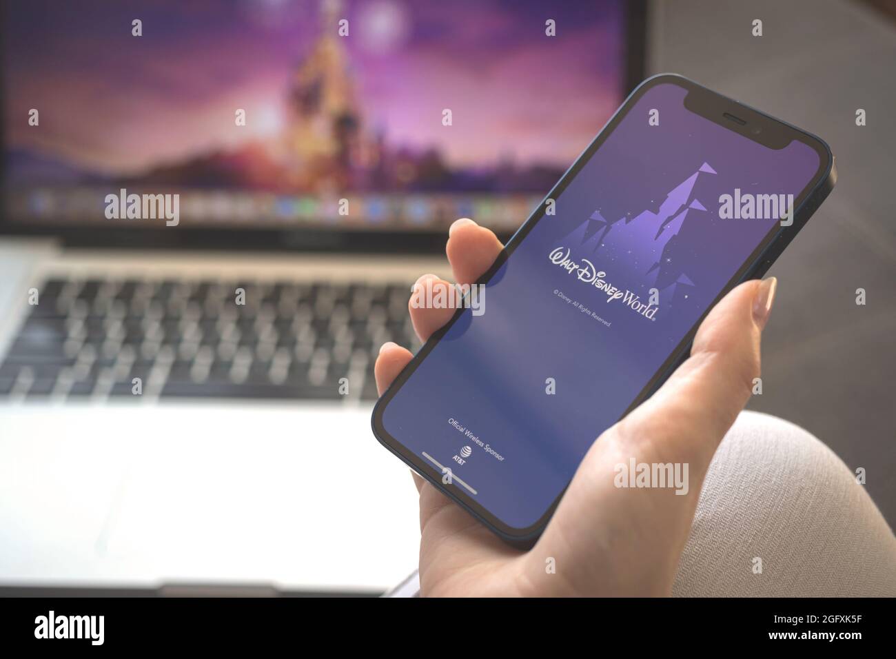 Kharkov, Ucraina - 23 agosto 2021: Logo dell'app Walt Disney World sullo schermo del telefono cellulare. Donna che usa Walt Disney World applicazione foto Foto Stock