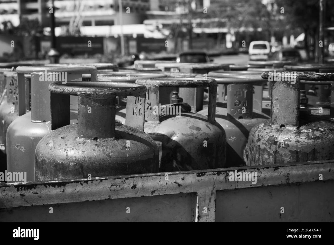 Bombole di gas per uso domestico con supporto al propano in fila, foto in bianco e nero Foto Stock
