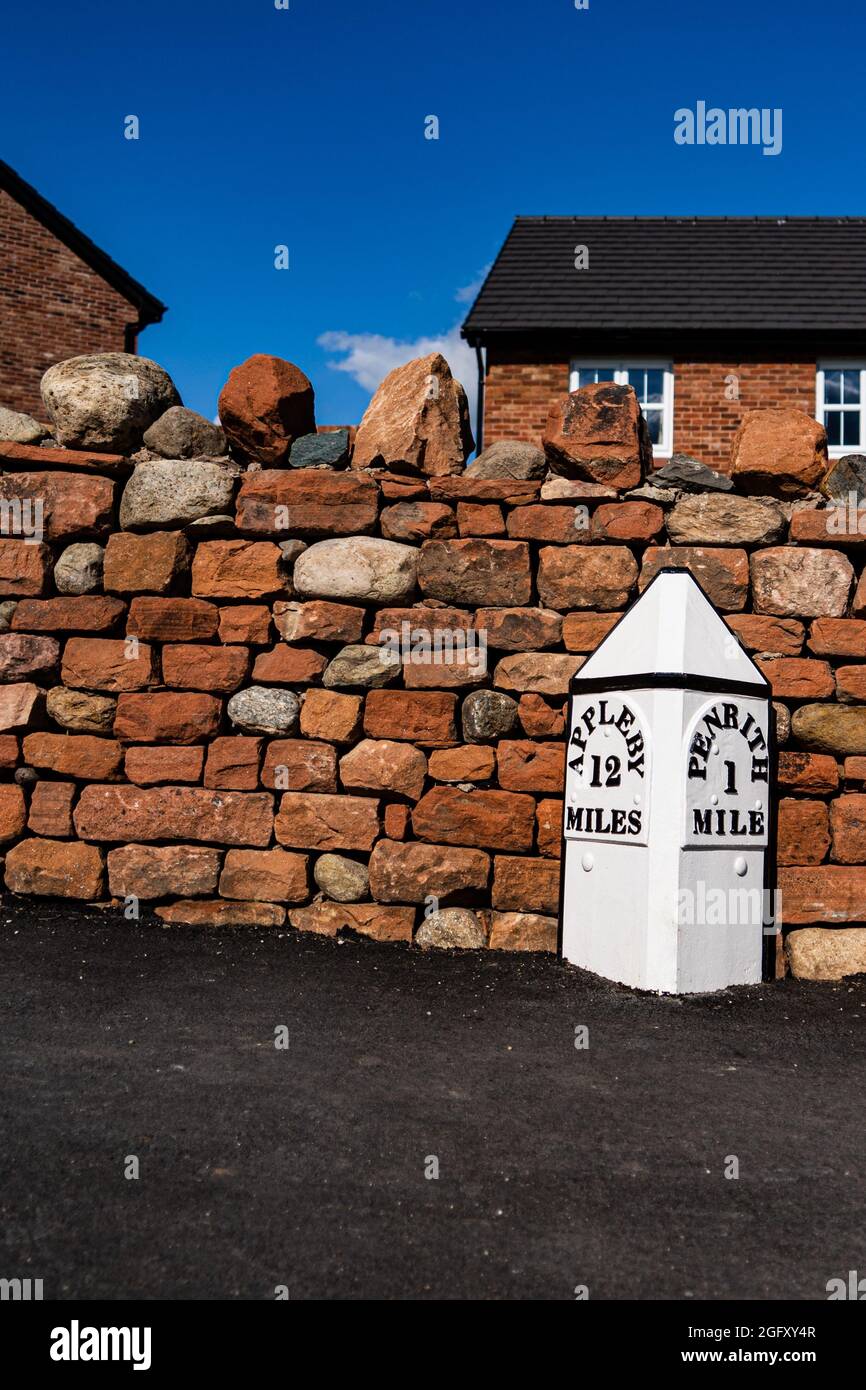 Un indicatore di miglio su una strada al di fuori di una nuova proprietà immobiliare alla periferia di Penrith Cumbria Regno Unito Foto Stock