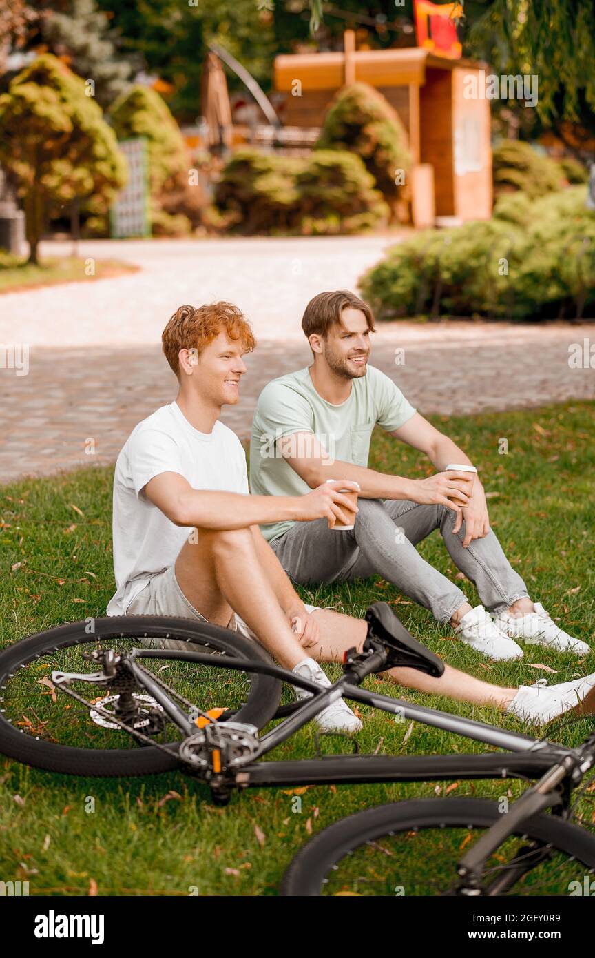 Due amici sportivi che riposano dopo l'allenamento ciclistico all'aperto Foto Stock