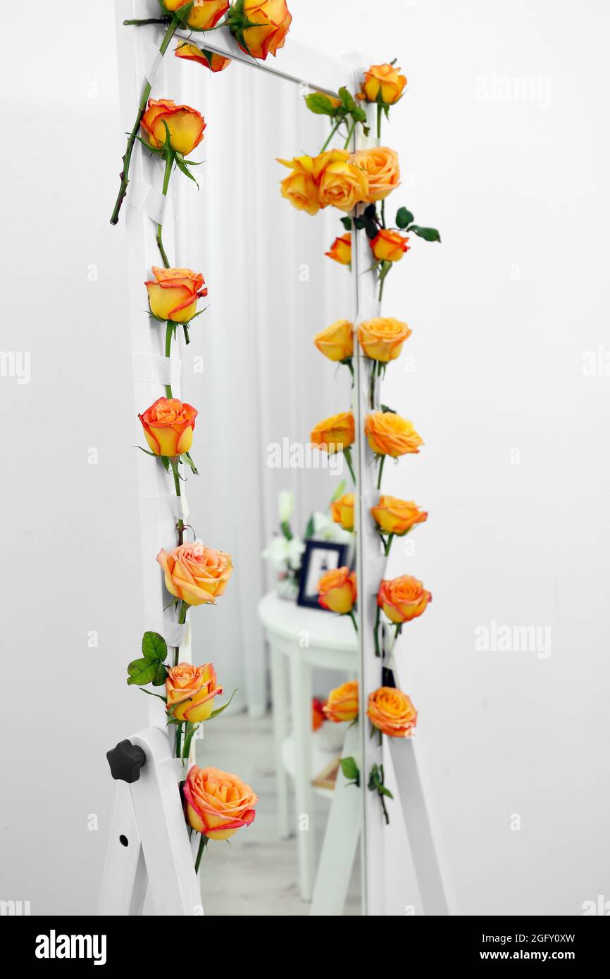 Specchio decorato con splendidi fiori vicino a muro bianco, primo piano  Foto stock - Alamy
