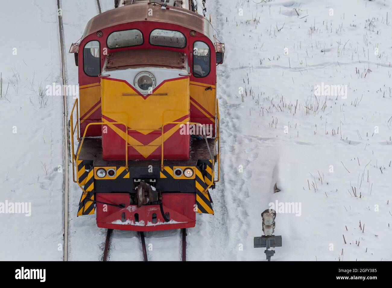 Locomotiva diesel da merda in una stazione ferroviaria coperta di neve. Il concetto di trasporto ferroviario Foto Stock