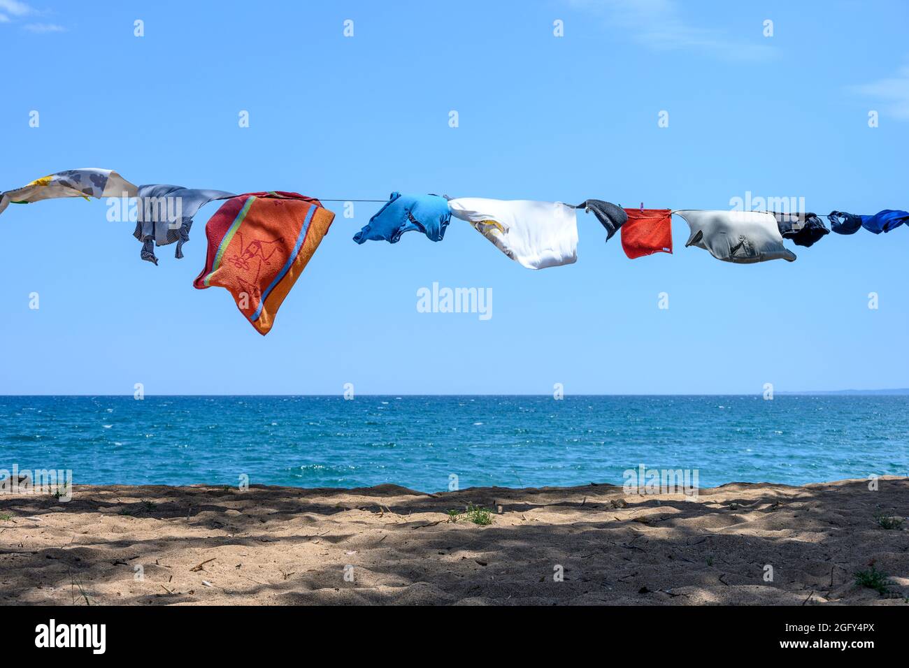 Camper vestiti su una linea di lavaggio vicino al mare su una spiaggia nel sud della Grecia. Foto Stock