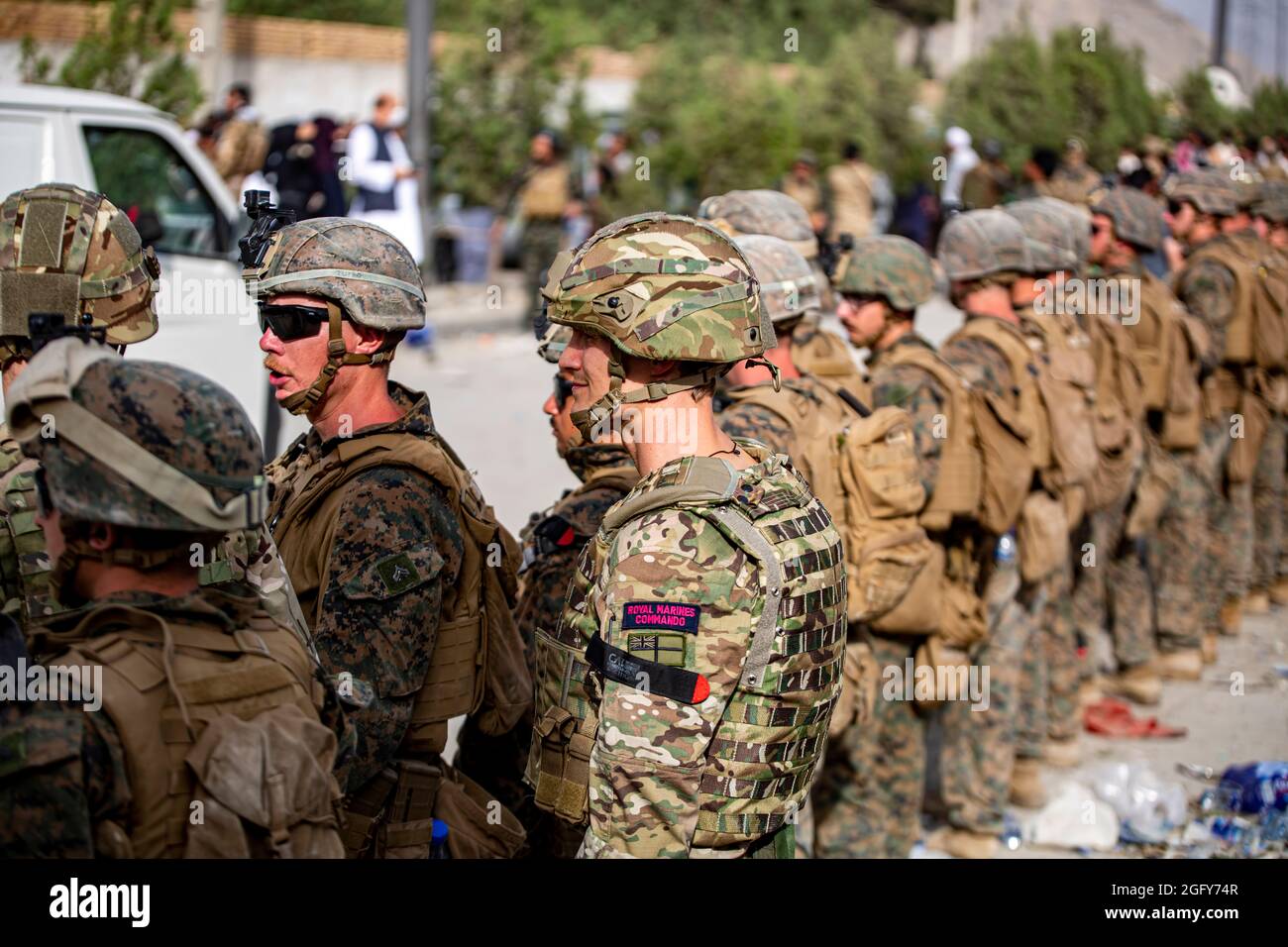 Regno Unito Royal Marine Commandos e Marines assegnati alla 24a unità di spedizione marina aiutano gli afghani attraverso un centro di controllo dell'evacuazione (ECC) all'aeroporto internazionale Hamid Karzai, 18 agosto. I membri del servizio degli Stati Uniti stanno assistendo il Dipartimento di Stato con un prelievo ordinato di personale designato in Afghanistan. (STATI UNITI Foto del corpo marino di 1° Ora. Mark Andries) Foto Stock