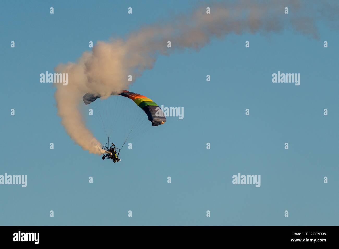 Un paracadute o un PPC alimentato che vola vicino a Quartzsite, Arizona, con una bomboletta di fumo che lascia dietro una scia di fumo. Foto Stock