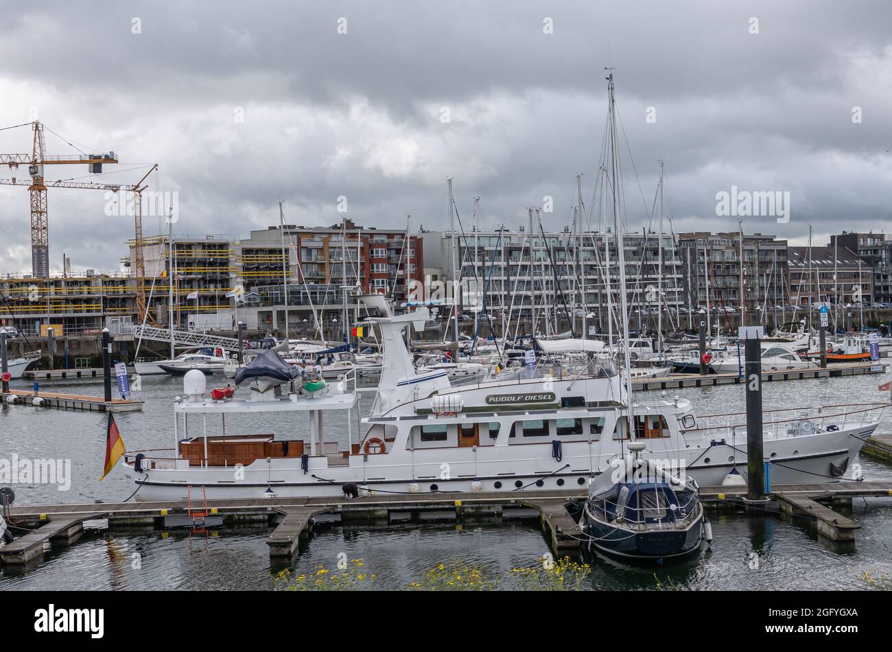 Zeebrugge Port, Belgio - 6 agosto 2021: Primo piano di Rudolf Diesel Yacht di lusso attraccato tra molte piccole imbarcazioni. Muro di edifici in retro u Foto Stock