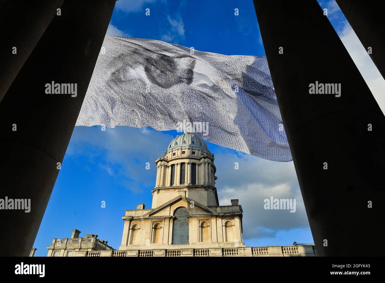 Greenwich, Londra, Regno Unito. 27 ago 2021. "We are watching" di Dan Acher viene lanciato oggi come parte del Greenwich and Docklands International Festival. La bandiera gigante è un occhio monumentale, composto da migliaia di ritratti provenienti da 190 paesi. Vola in alto sopra i giardini e lo splendido edificio dello storico Old Royal Naval College. Credit: Imagplotter/Alamy Live News Foto Stock