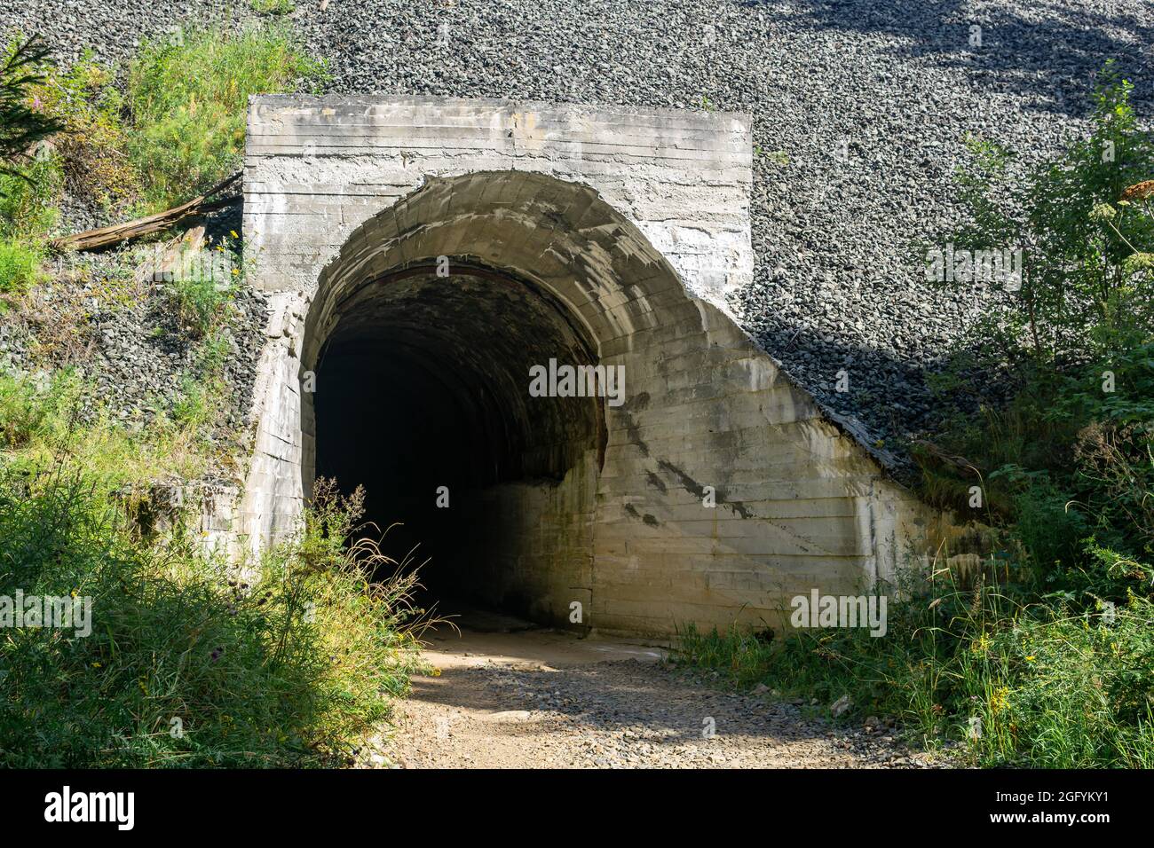 la strada passa in un misterioso tunnel scuro sul fianco della montagna Foto Stock