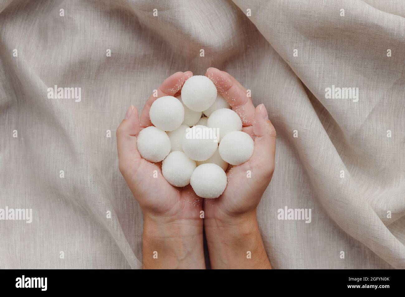 Mani femminili che tengono solido shampoo naturale fatto a mano o palline di scrub di zucchero. Vista dall'alto Foto Stock
