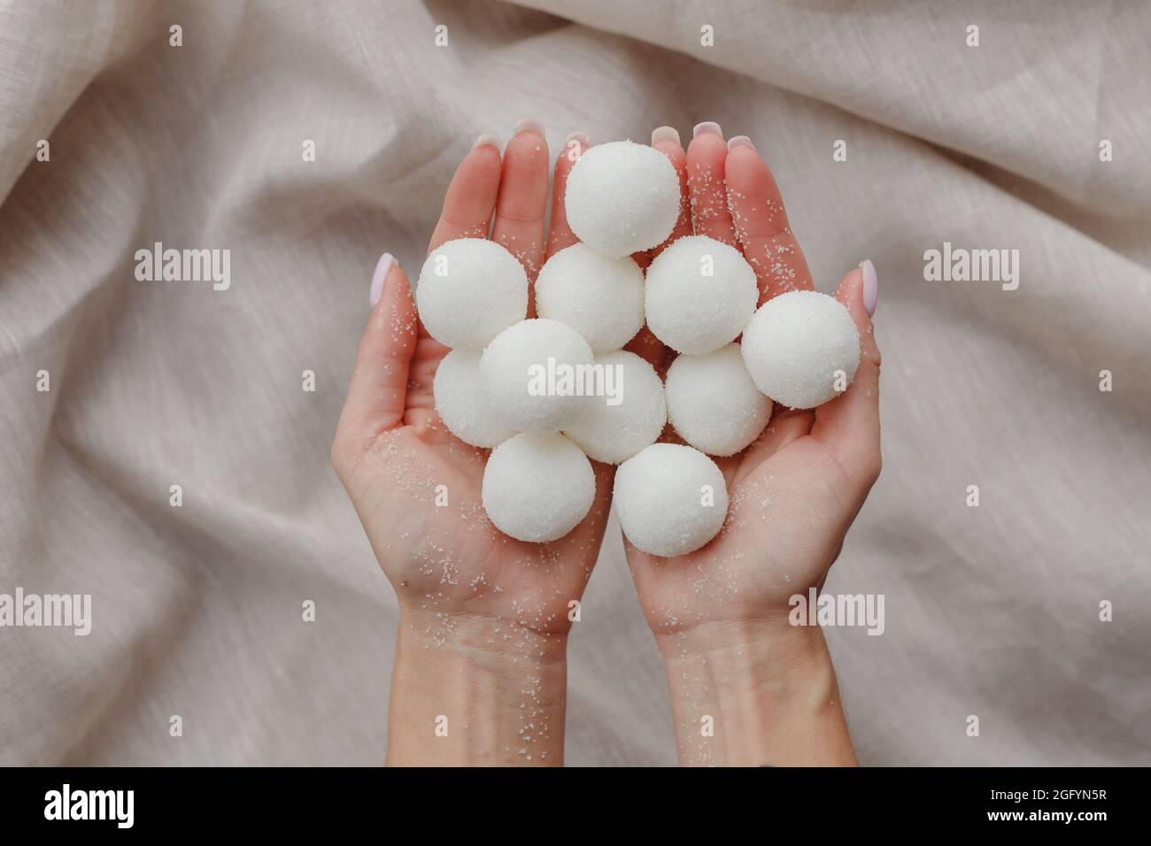 Mani femminili che tengono solido shampoo naturale fatto a mano o palline di scrub di zucchero Foto Stock
