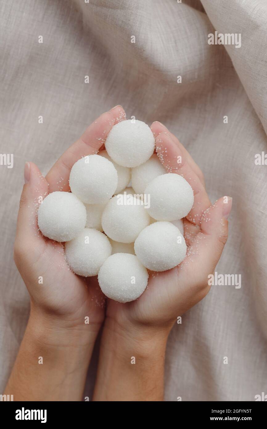 Mani femminili che tengono solido shampoo naturale fatto a mano o palline di scrub di zucchero. Vista dall'alto Foto Stock