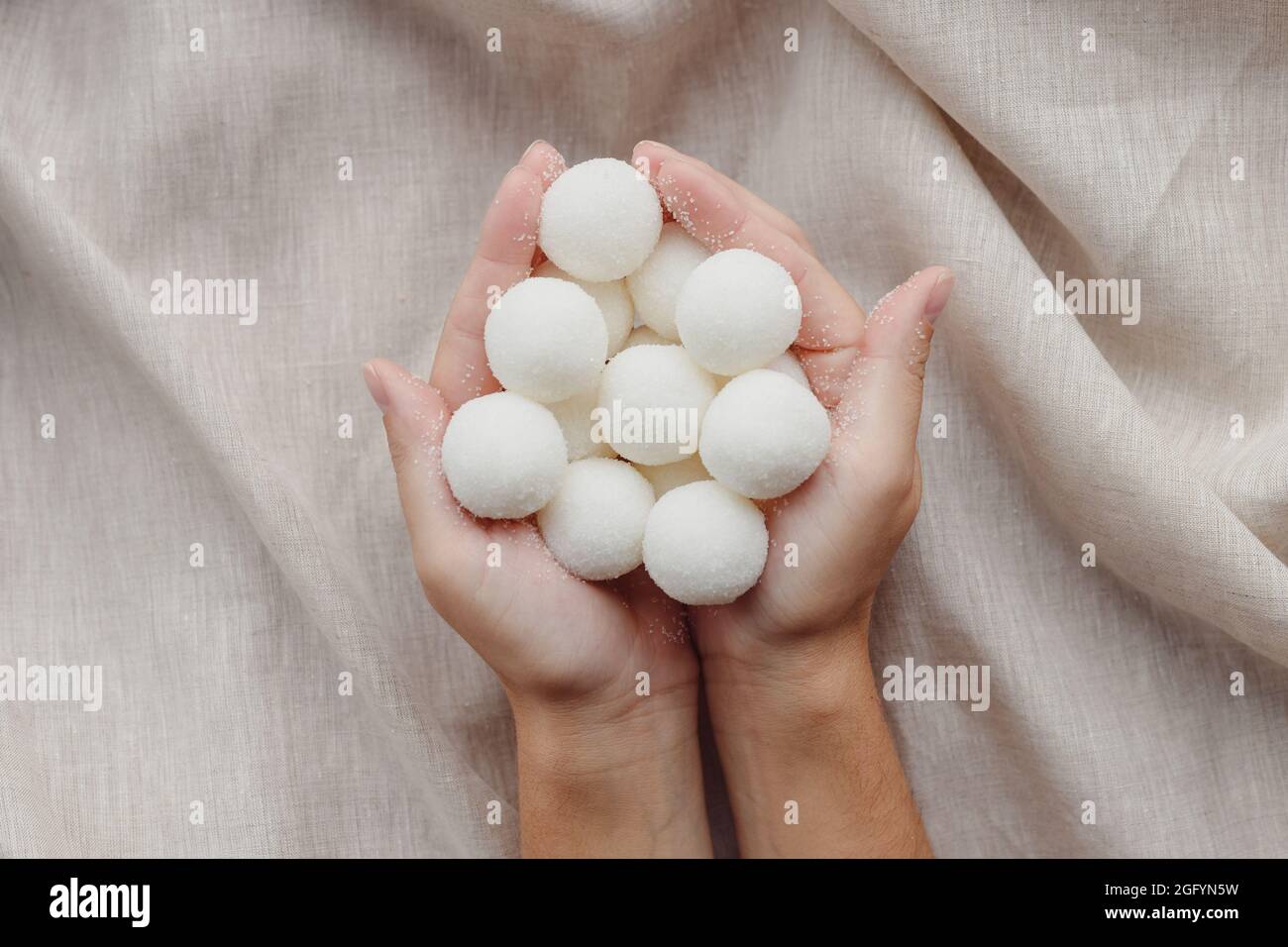 Mani femminili che tengono solido shampoo naturale fatto a mano o palline di scrub di zucchero Foto Stock
