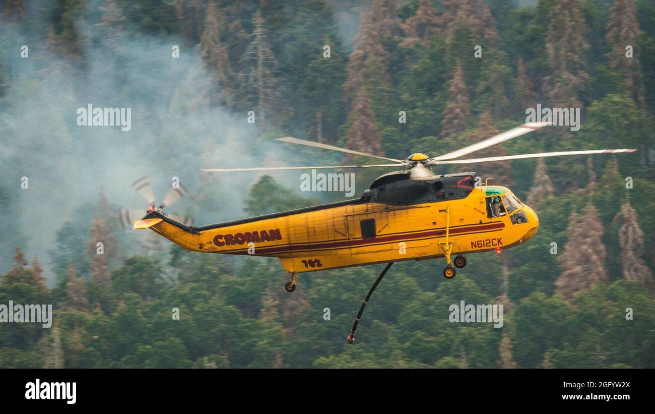 Le operazioni di Cedar Fire includono il rilascio in elicottero di acqua quando necessario durante il Cedar Fire nella Sequoia National Forest vicino Posey, CA, domenica 22 agosto 2016. Il tubo sotto l'elicottero consente di riempire i serbatoi d'acqua mentre si sorvolano i corpi d'acqua, in questo caso un laghetto vicino alla comunità Balance Rock nella contea di Tulare. USDA Foto di Lance Cheung. Per ulteriori informazioni si veda: www.usda.gov www.fs.fed.us @usda @Forestservice Video il cuore di un pompiere https://youtu.be/QxJFIfkOQLY Foto Stock