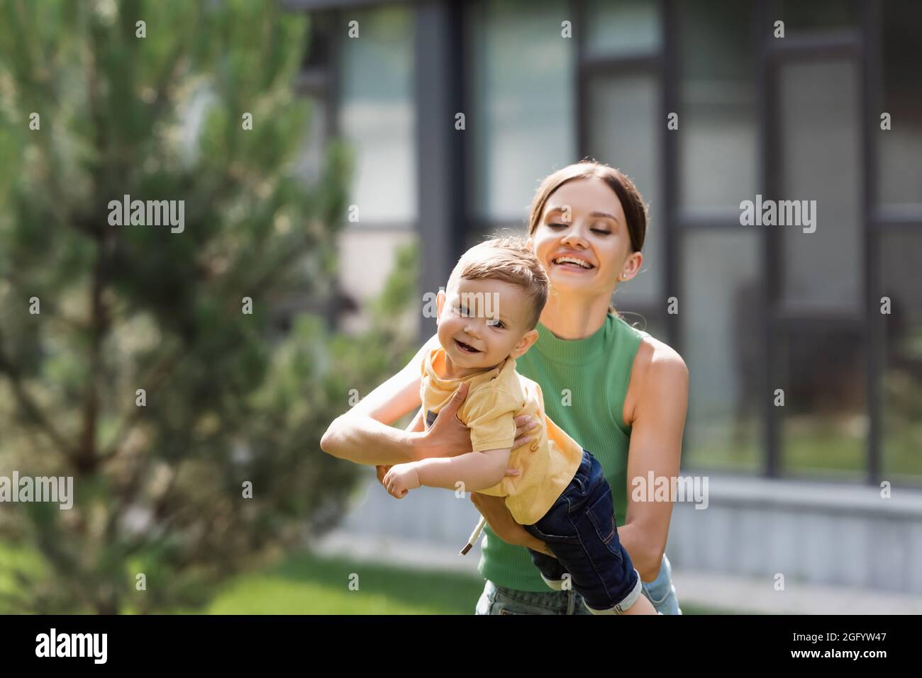 madre allegra e giovane che tiene in braccio figlio toddler Foto Stock