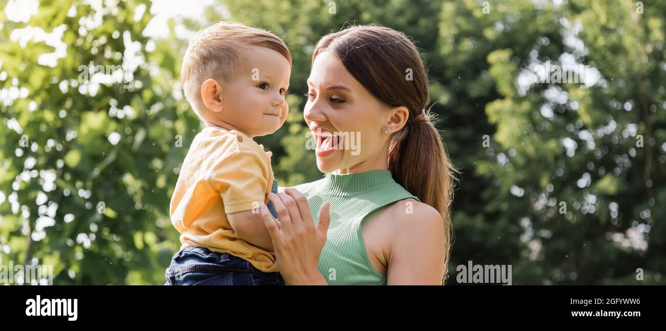 stupito giovane madre che tiene in braccio figlio toddler, banner Foto Stock